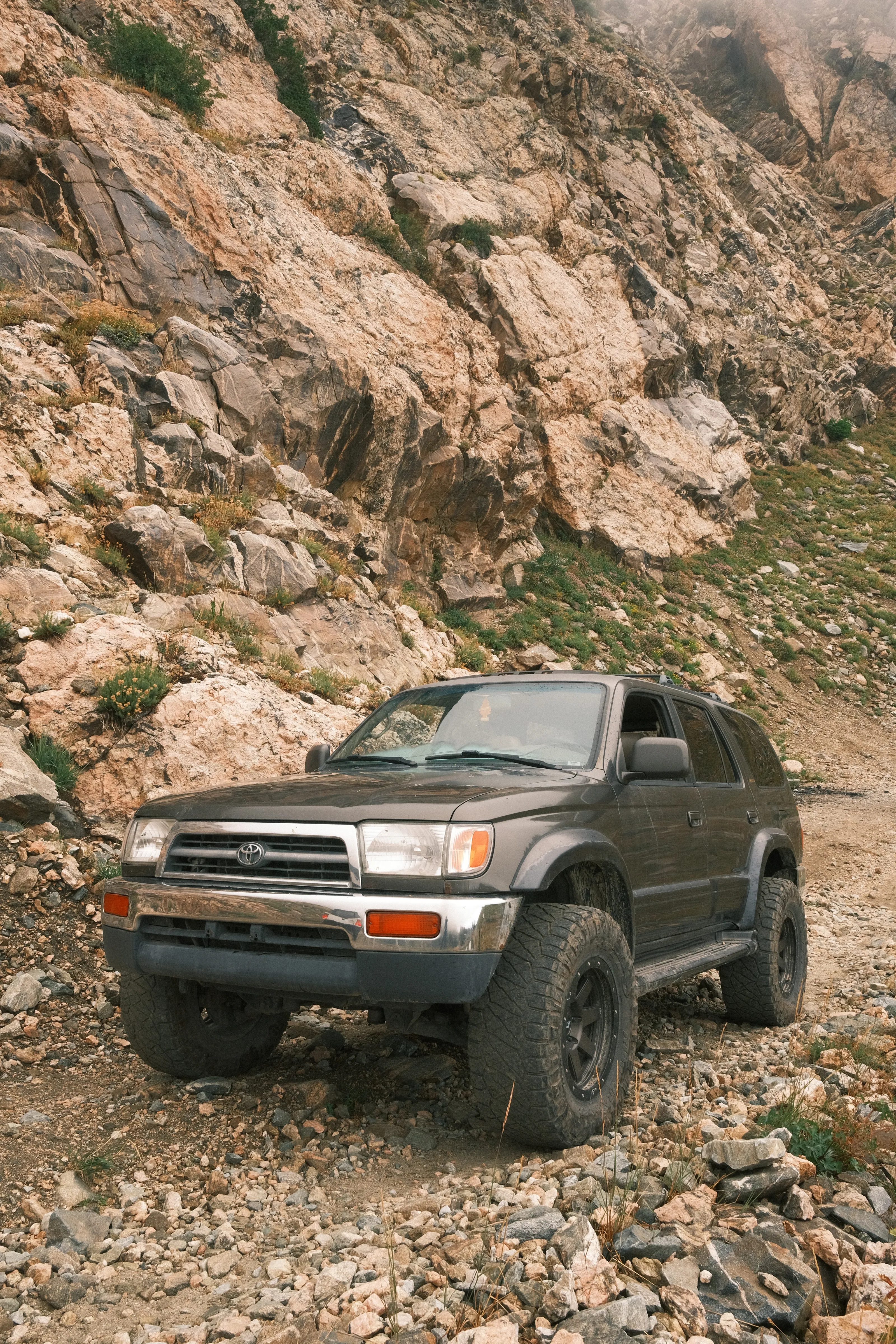 Grey 1998 Toyota 4Runner coming down a rocky switchback below a cliff